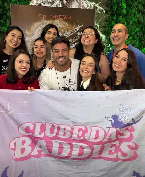 Leitoras com autora em sessão de autógrafos e bandeira do Clube das Baddies